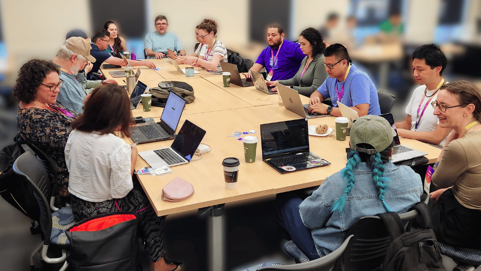 pyOpenSci contributors collaborating at a conference sprint table